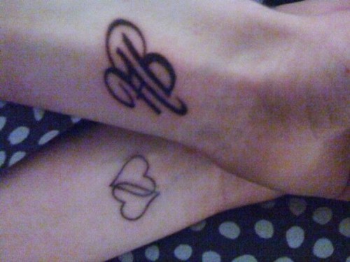 My tattoo (hearts) and my boyfriend's tattoo (my initials) both on our left 