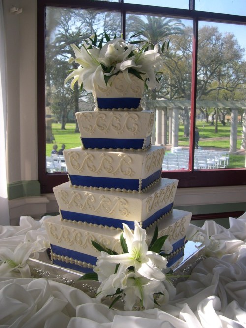 Five tier wedding cake with piped scrolling and royal blue satin ribbon trim