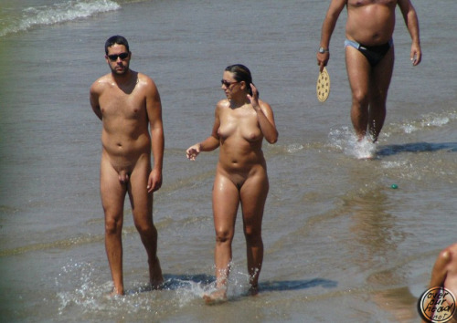 ramblingtaz:

Naturist Couple enjoying the beach naturally without shame. Avoid tan line, go naked.  If you can’t stand the heat…get out of your clothes.