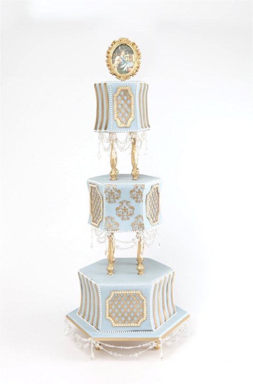 Gorgeous 3tiered blue and gold wedding cake with gold pillars and 